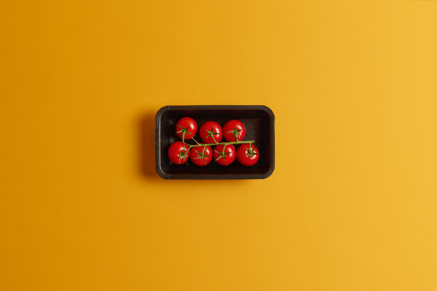 升华健康的小樱桃西红柿放在一个黑色的容器里 在黄色的背景下隔离开来美味的蔬菜可以用来做番茄汁或素食沙拉非常美味的作物配料饮食果汁
