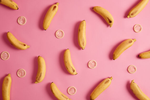 玫瑰香粉红色背景的香蕉和避孕药安全关系的热带风味安全套消除怀孕风险医疗保健提供者安全套强度 柔韧性 可靠性测试愉悦疾病乳胶