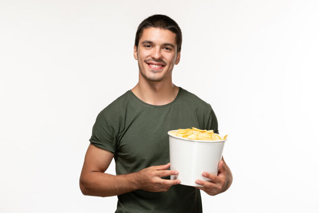 土豆正面图身着绿色t恤的年轻男性 在白墙上微笑的土豆cips电影《孤独的人》电影院电影电影杯子