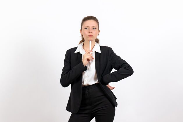 工作前视年轻女性穿着严格的经典西装拿着笔在白色背景上工作的女性工作服服装成功钢笔