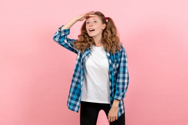 漂亮前视图穿着蓝色格子衬衫的年轻女性在粉色背景上摆姿势青春情感女孩儿童模特时尚衬衫姿势人