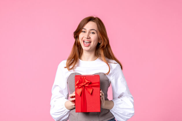 年轻女性正面图：年轻女性 红色包装 粉色背景 三月横向性感礼物 香水 照片 金钱平等的女人礼品包装香水