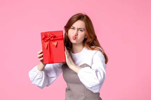 年轻女性正面图：年轻女性 红色包装 粉色背景 相亲日期 三月 横向性感礼物 香水 女士 照片 钱包装礼品香水