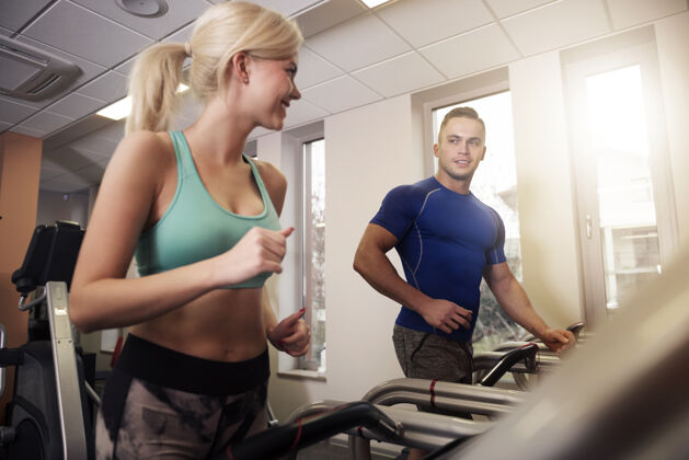 面对面搭档是健身房的好动力运动机器肌肉建设女人