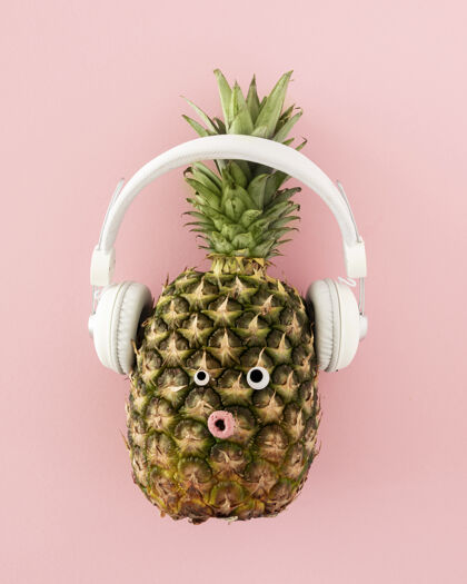 菠萝带耳机的菠萝顶视图粉色背景美味垂直