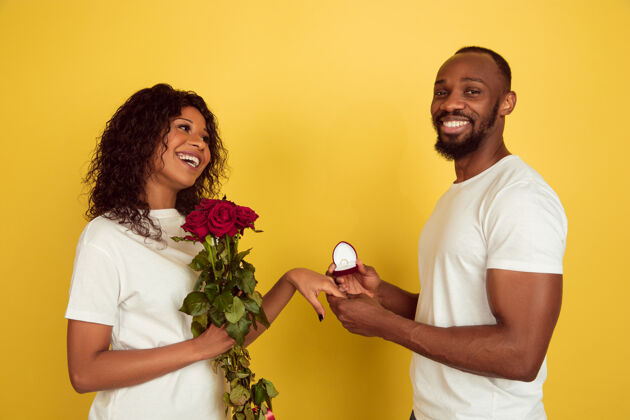 人带着玫瑰和结婚戒指的年轻夫妇欢呼男性肖像