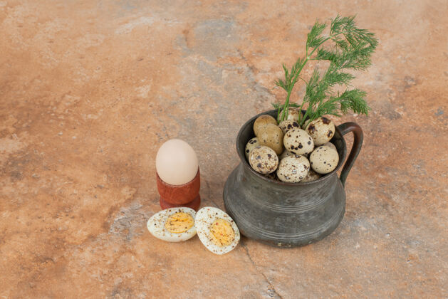 绿色鹌鹑蛋放在大理石桌上的杯子上杯子鸡蛋鹌鹑