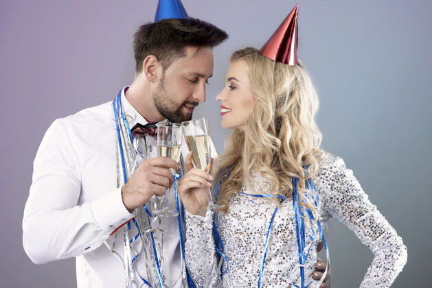 男人一对年轻夫妇在庆祝新年前夜金发饮酒欲望