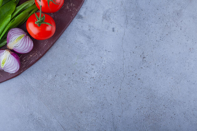 生的新鲜的西红柿和洋葱放在木板上蔬菜平铺混合