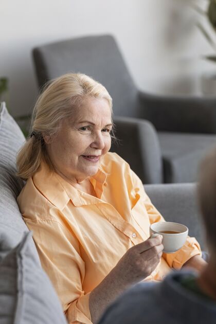 垂直特写拿着杯子的退休妇女老年人快乐近距离
