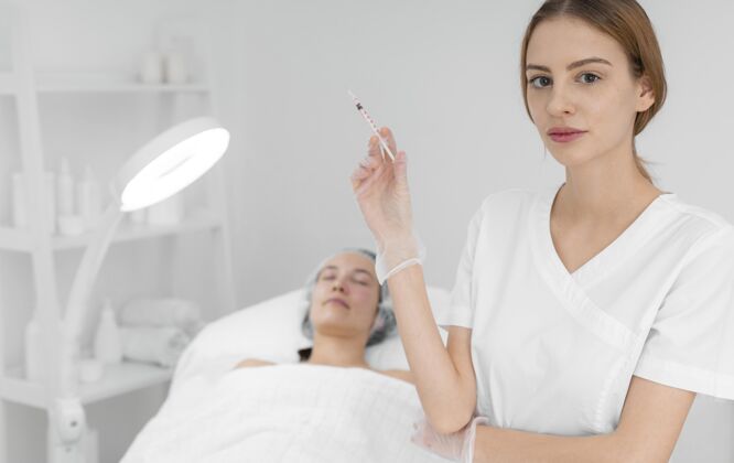 美容治疗美容师在美发厅为女性客户注射填充物化妆品沙龙治疗