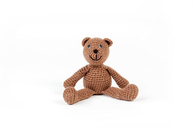 娃娃可爱的棕色泰迪熊坐在白色的表面与白色的背景天真小毛绒绒
