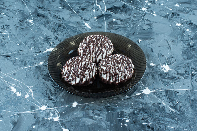巧克力曲奇蓝色玻璃盘上的巧克力饼干可口糕点风味