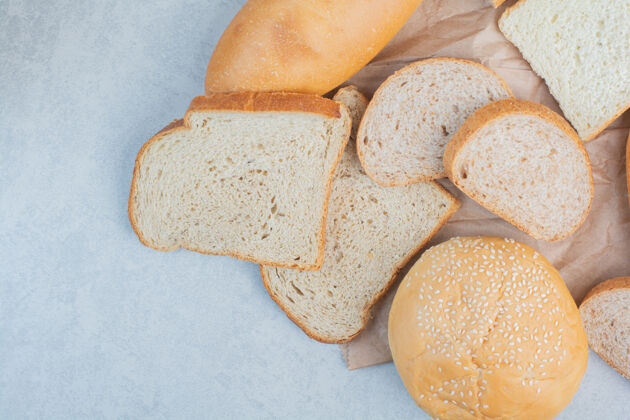 面包蓝色背景芝麻面包片和小面包高品质照片黑麦自制切片