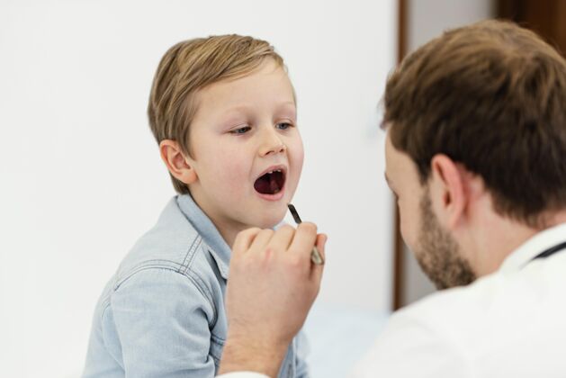 医生医生仔细检查孩子的嘴特写健活方式