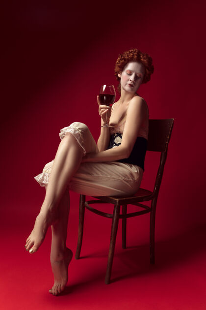 历史中世纪红发女公爵 身穿黑色紧身衣和睡衣 坐在红色空间的椅子上 端着一杯葡萄酒好的葡萄酒服装