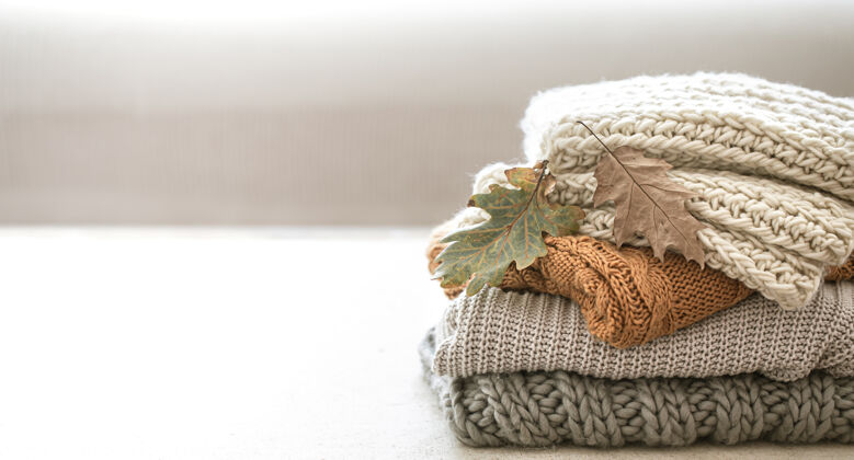 合成一堆温暖的针织物从秋天的衣柜里拿出来 放在模糊的白色空间里毛衣针织品针织