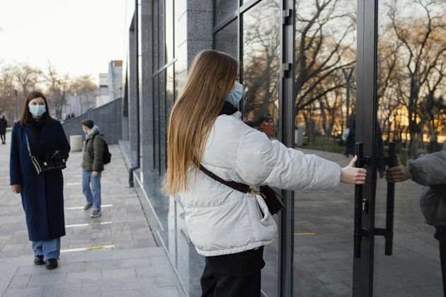 社会距离戴着面具开门的女人措施口罩预防