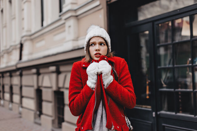 手套那个戴着雪白针织帽子和手套的女孩冻得浑身发抖 穿着红色外套女孩人温暖