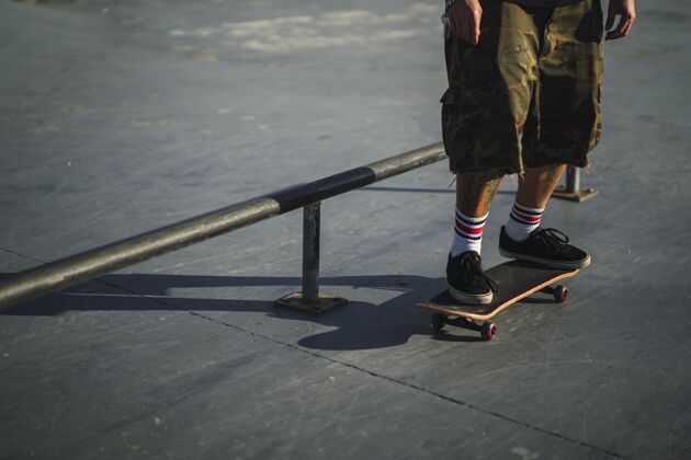 健康年轻男子在公园里玩滑板玩不同的把戏技能极限街道