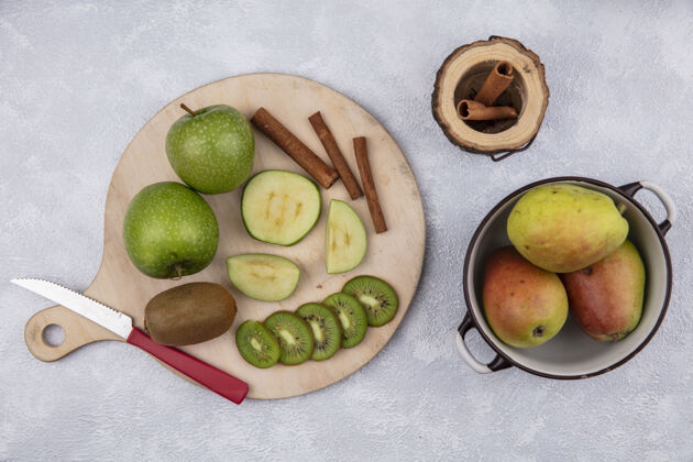 水果在白色背景上 用刀架上的肉桂青苹果和猕猴桃炖锅俯瞰梨甜食绿色肉桂