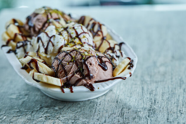 巧克力雪糕加香蕉 巧克力和洒在白色盘子上食物盘子冰淇淋