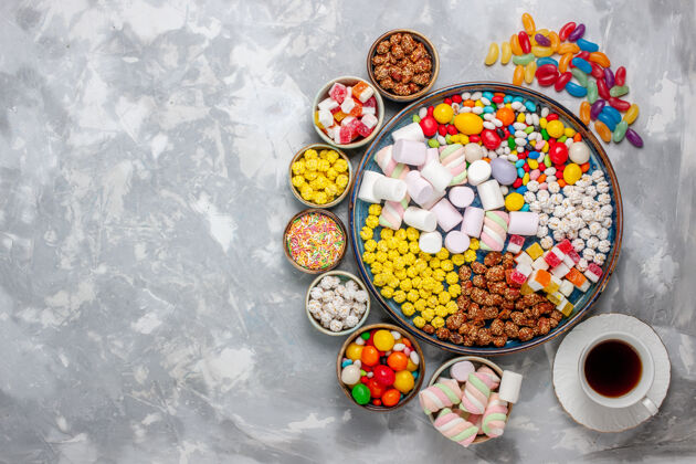 观点顶视图糖果组成不同颜色的糖果与棉花糖和茶的白色办公桌糖糖果邦邦甜的知己顶部糖果棉花糖