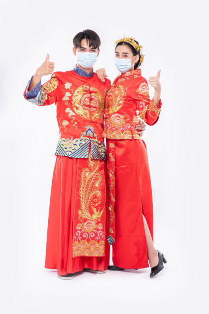 竖起大拇指男男女女穿旗袍西服戴口罩竖起大拇指庆祝活动将在农历新年举行中国民族人成人