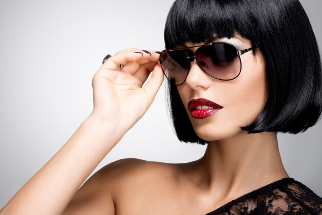 嘴唇一个漂亮的黑发女人的时尚肖像 带着红色太阳镜的发型黑色头发性感漂亮