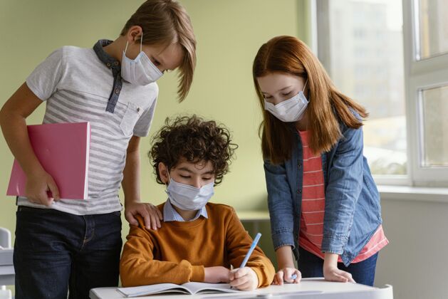 孩子戴着医用口罩的孩子们在学校学习的正面图面罩水平学习