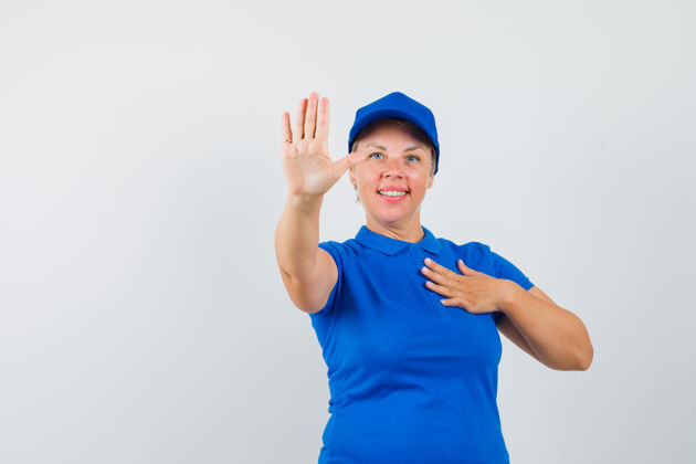 停止穿蓝色t恤的成熟女性 展示停止手势 看起来很自信女人可爱人