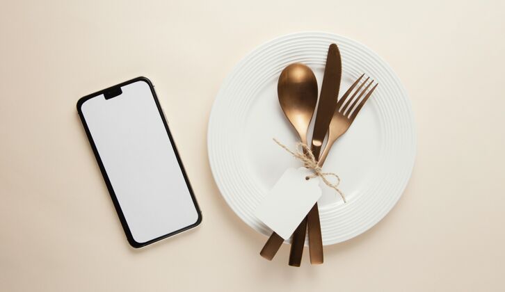 餐具用空智能手机布置优雅的餐具陶器组合的装饰的