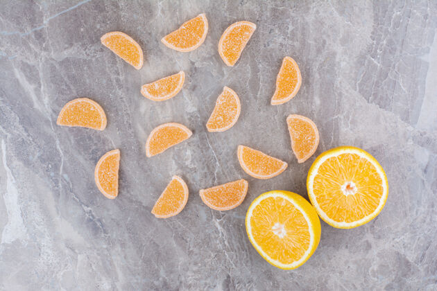 糖新鲜的橘子片和甜甜的果酱放在大理石背景上甜味美味糖果