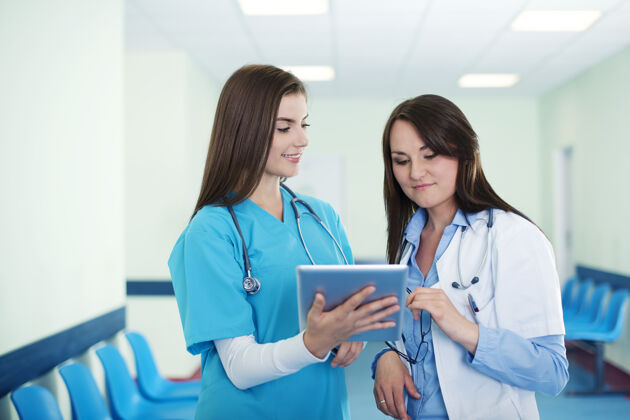 医疗职业女医生在数字平板电脑上检查结果护理指示器团队
