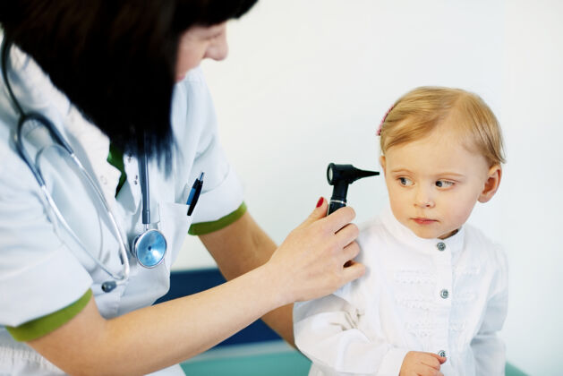 工作儿科医生在给女婴做耳科检查听诊器幼儿诊所