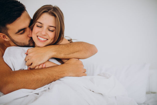 浪漫年轻夫妇一起躺在床上家庭睡眠毯子