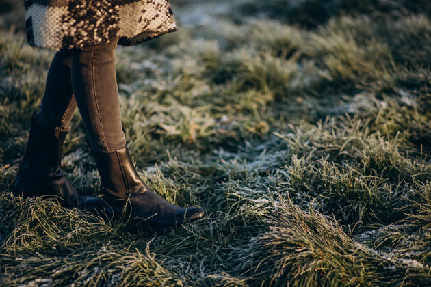 公园女人的脚在白霜覆盖的草地上街头风格年轻可爱