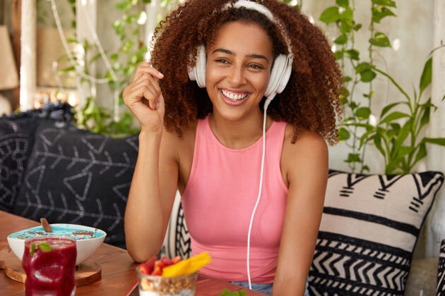 鸡尾酒快乐的美籍黑人女性梅洛曼用耳机大音量听音乐广播镜头旋律