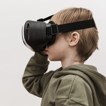 电子侧视图的小男孩使用虚拟现实耳机设备虚拟现实科技