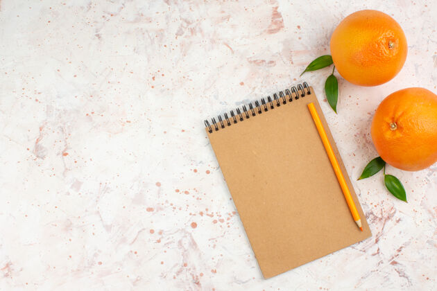 柑橘顶视图新鲜橙子铅笔记事本上明亮的表面与复制空间铅笔顶部橘子