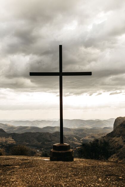 符号在多云的灰色天空下 您可以俯瞰群山天主教祈祷山