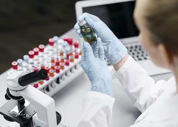 智力实验室里的女研究员拿着试管和疫苗瓶瓶子科学家水平