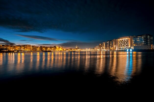 建筑夜晚天际线的全景照片 水面上的光线反射倒影城市景观水