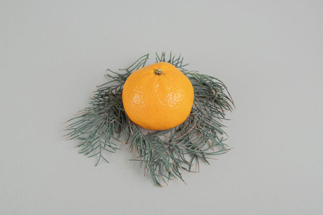 食用一个完整的新鲜橘子在灰色的背景上圆形热带美味