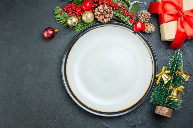 餐盘上图为餐桌圣诞树冷杉枝针叶树锥礼盒左侧黑色背景盘子风景瓷器