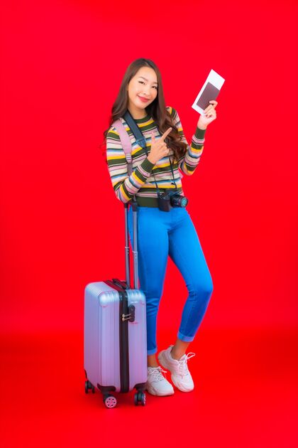 乐趣画像美丽的亚洲年轻女子带着行李和登机牌在红墙上中国快乐行李