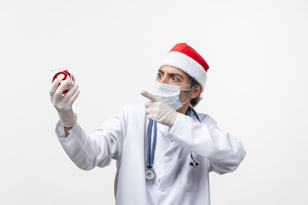 成人男医生手持新年树玩具健康病毒男人工作圣诞节