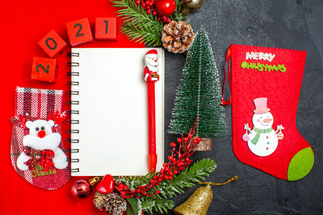 杉木上图为黑色背景上的螺旋笔记本装饰配件杉木树枝xsmas袜子编号红色餐巾和圣诞树视图螺旋笔记本书签