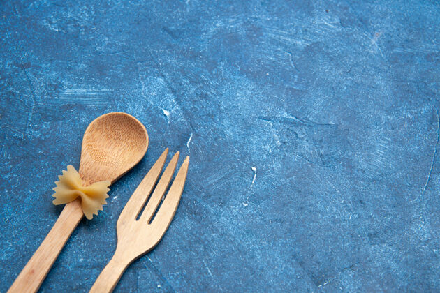 叉子底视图木制叉子勺farfalle上勺蓝色桌子上的自由空间吃饭风景晚餐