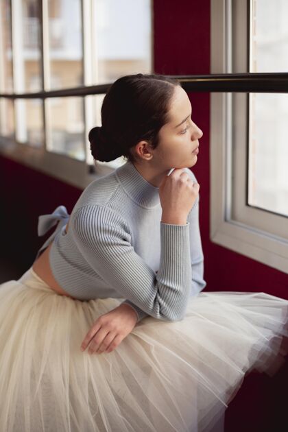 艺术芭蕾舞演员穿着芭蕾舞裙透过窗户看的侧视图芭蕾舞演员裙子表演